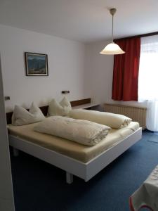 ザンクト・ヴォルフガングにあるHaus Alpenroseの赤いカーテンが備わる客室の大型ベッド1台分です。