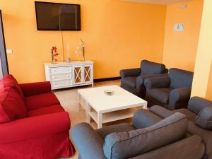 a living room with two couches and a tv at Hotel Anfora in Melilla