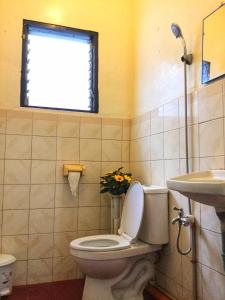 a bathroom with a toilet and a sink and a window at May’s Home Away from Home in Cebu City