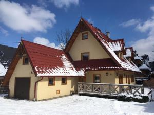 a house with a red roof in the snow at Do Daniela in Zakopane