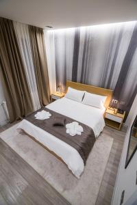 1 dormitorio con 1 cama grande y 2 toallas. en Hotel Regal, en Korçë