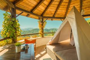 a bed in a tent on a deck with a table at Villa Melolia in Ýpsos