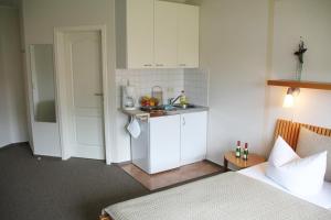 a room with a bed and a kitchen with a sink at Pension "Zur Steilküste" in Boltenhagen