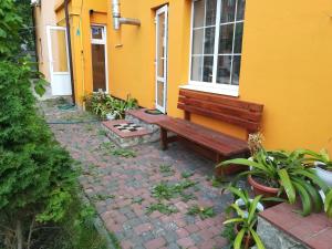 un banc assis devant une maison jaune dans l'établissement Апельсин, à Myrhorod