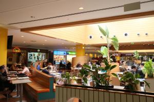 a group of people sitting at tables in a restaurant at Chen 1 in Portimão