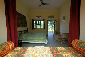 a bedroom with two beds and a window at Krishna Ranch in Udaipur