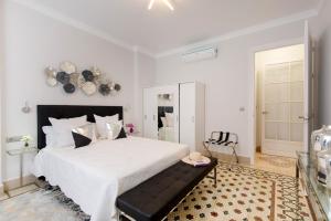 マラガにあるPiso Centro Malaga Excelente Ubicacion Nuevoのベッドルーム(白い大型ベッド1台、黒いヘッドボード付)