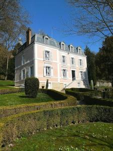 una gran casa blanca con arbustos delante en Maison d'hôtes Stella Cadente, en Provins