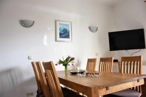 a dining room table with chairs and a television at Apartment - Direkt am Wasser in Ostseebad Karlshagen