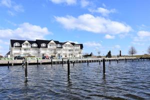 a large house on a pier next to a body of water at Apartment - Direkt am Wasser in Ostseebad Karlshagen