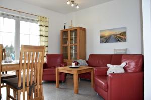 a living room with a red couch and a table at Apartment - Direkt am Wasser in Ostseebad Karlshagen