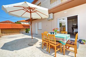 stół i krzesła z parasolem na patio w obiekcie Gabi 2 w mieście Zadar