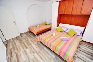 2 łóżka pojedyncze w pokoju z drewnianą podłogą w obiekcie Gabi 2 w mieście Zadar