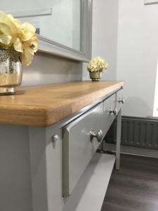 a kitchen with a wooden counter top with flowers on it at Antrim Coast Apartments in Cushendall