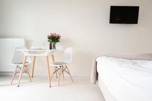 クラクフにあるRomantic Sky Apartment- 15th floorのテーブルと椅子2脚とベッドのある寝室 +11枚の写真