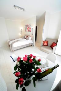 een woonkamer met een tafel met rozen erop bij Romantic Sky Apartment- 15th floor in Krakau