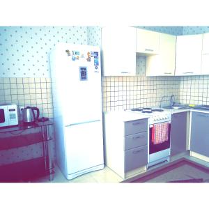 uma cozinha com um frigorífico branco e um fogão em Panoramic apartment in Sarmat house em Astana
