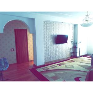 uma sala de estar com uma porta vermelha e uma televisão na parede em Panoramic apartment in Sarmat house em Astana
