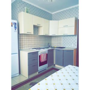 uma cozinha com armários brancos e um forno com placa de fogão em Panoramic apartment in Sarmat house em Astana