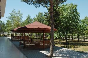a gazebo in a park with a tree at Burgaz Resort Aquapark Hotel in Kırklareli