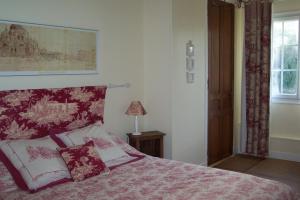 1 dormitorio con 1 cama con manta roja y blanca en Domaine de Beauvilliers, en Chaumontel