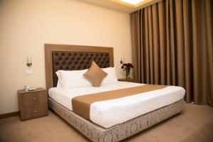 a bedroom with a large bed in a hotel room at Bzommar Palace Hotel in Harisa