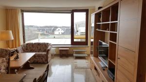 - un salon avec un canapé et une grande fenêtre dans l'établissement Wohnung-Westerlandblick, à Westerland