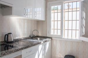 une cuisine blanche avec un évier et une fenêtre dans l'établissement Cozy vacation apartment in Los Gigantes, à Acantilado de los Gigantes