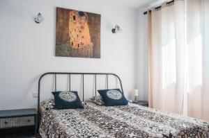 - une chambre avec un lit doté d'oreillers bleus et d'un tableau dans l'établissement Cozy vacation apartment in Los Gigantes, à Acantilado de los Gigantes