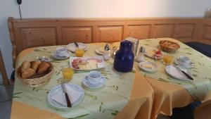 uma mesa com uma toalha de mesa com comida em Gästezimmer Fuchs em Ramsthal