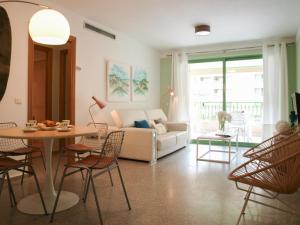 バレンシアにあるApartUP Patacona Beach IIのリビングルーム(ソファ、テーブル、椅子付)