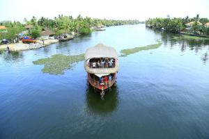 un barco con gente en él en un río en Vaishnav Tours en Alleppey