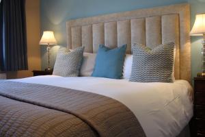 a bedroom with a bed with blue and white pillows at Pinfield Boutique Hotel in Slough