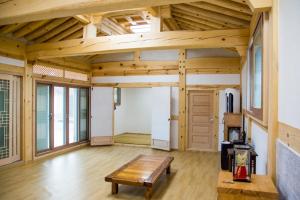 Habitación grande con techo de madera y mesa de madera. en Hanok 1st Street en Gyeongju