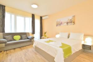 Un dormitorio con una cama grande y un sofá. en Central studio 1, en Burgas
