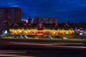 un edificio con coches estacionados en un estacionamiento por la noche en Hotel Pegas, en Krasnodar