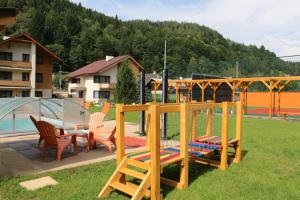 einen Spielplatz mit Stühlen und einer Schaukel im Hof in der Unterkunft Wellness Simply Relax - Chopok- privátna vírivka, sauna in Tale
