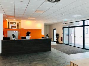 an office lobby with a reception desk and glass doors at Hotel Staffelseestraße in Munich