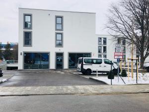 ein weißer Van vor einem Gebäude geparkt in der Unterkunft Hotel Staffelseestraße in München