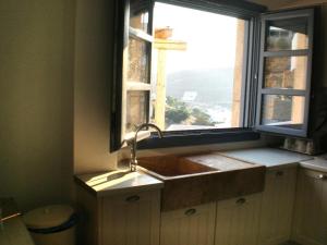 a kitchen with a sink and a window at Luxury house in the island of Patmos in Grikos