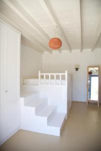 a white room with a staircase and a bed at Luxury house in the island of Patmos in Grikos
