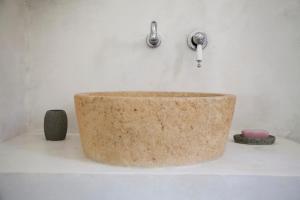 a bathroom with a stone sink and a faucet at Luxury house in the island of Patmos in Grikos