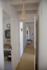 a hallway with white walls and a ceiling with a light fixture at Luxury house in the island of Patmos in Grikos
