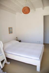 a white bed in a white room with a lamp at Luxury house in the island of Patmos in Grikos