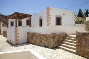 a house with a stone wall and stairs at Luxury house in the island of Patmos in Grikos