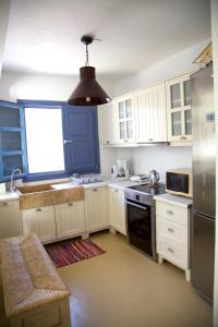 a kitchen with white cabinets and a large window at Luxury house in the island of Patmos in Grikos