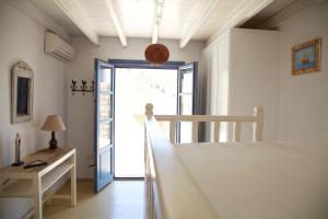 a bedroom with a bed and a window and a door at Luxury house in the island of Patmos in Grikos