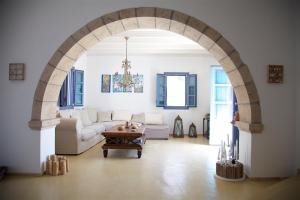 an archway in a living room with a couch and a table at Luxury house in the island of Patmos in Grikos