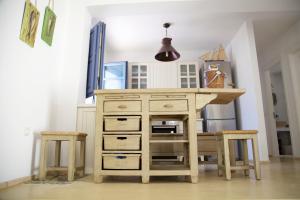 a wooden dresser with a desk and two stools at Luxury house in the island of Patmos in Grikos
