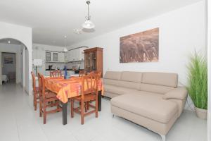 sala de estar con sofá, mesa y sillas en Ocean and Relax Apartment, en Corralejo